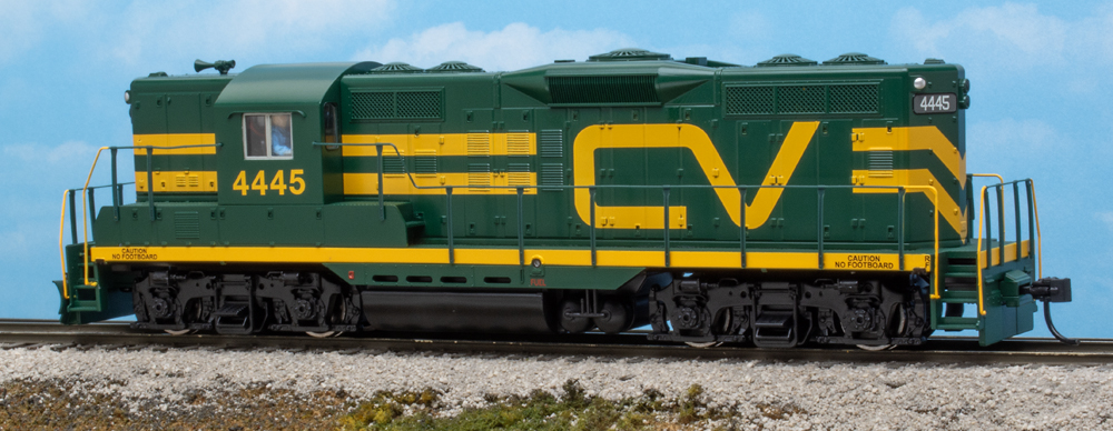Color photo of HO scale road switcher painted green and yellow on scenicked base.