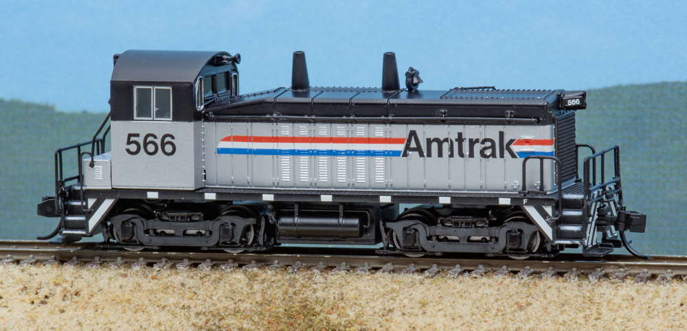 Color photo of N scale end-cab switcher painted silver and black with red, white, and blue stripes.