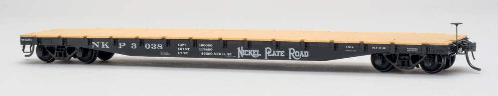 Color photo of HO scale flatcar painted black with white graphics and tan simulated wood plastic deck.