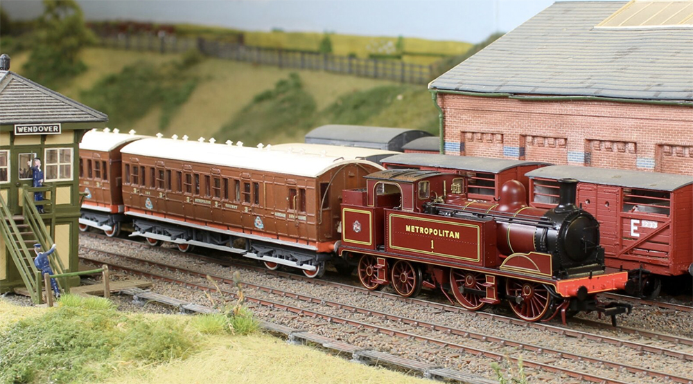 A red model steam locomotive on a model railroad layout
