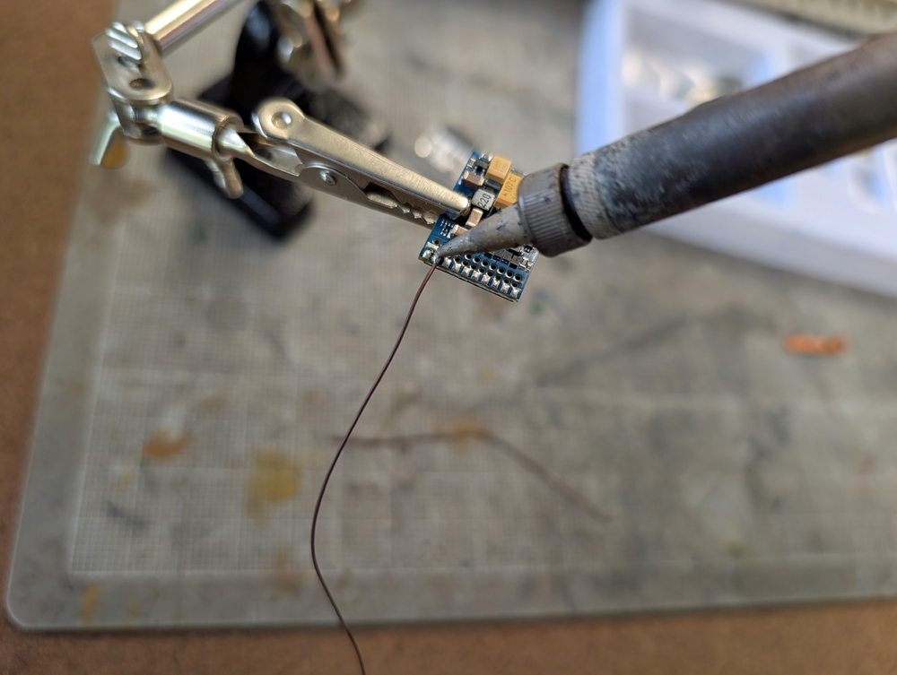 A soldering iron unsoldering a wire from a circuit board