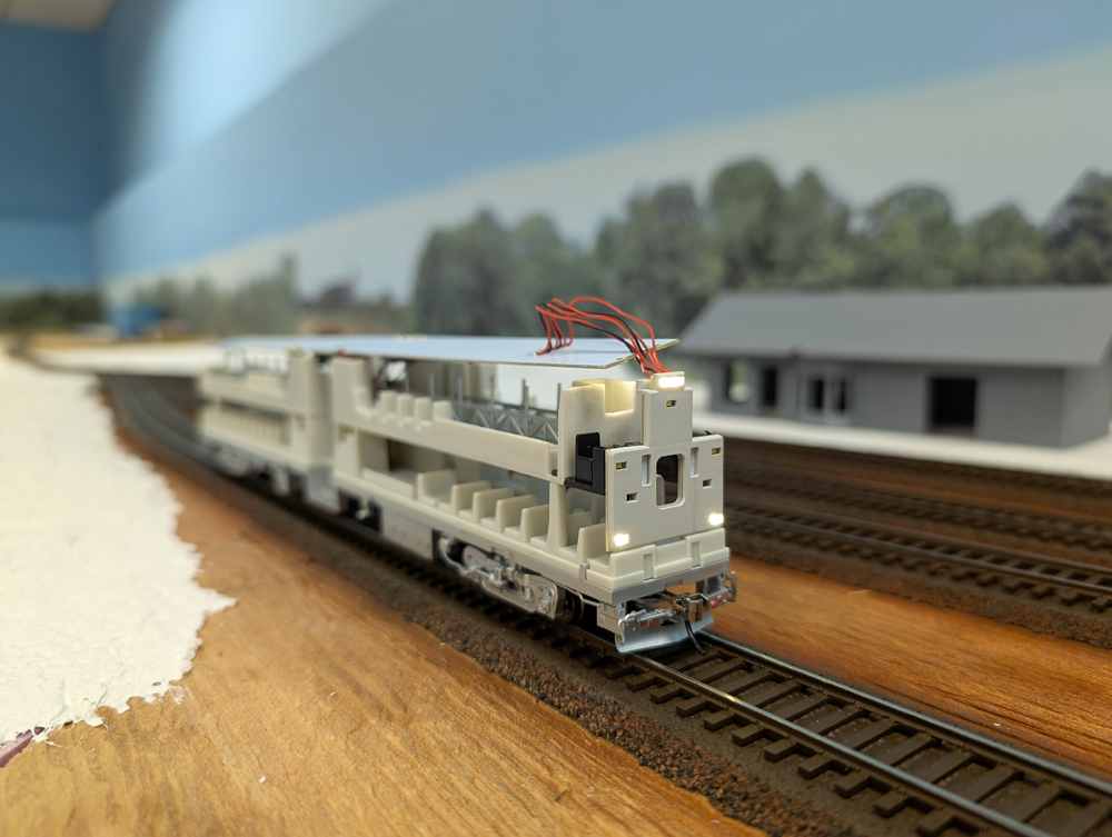 An HO scale passenger car interior with lights on the front