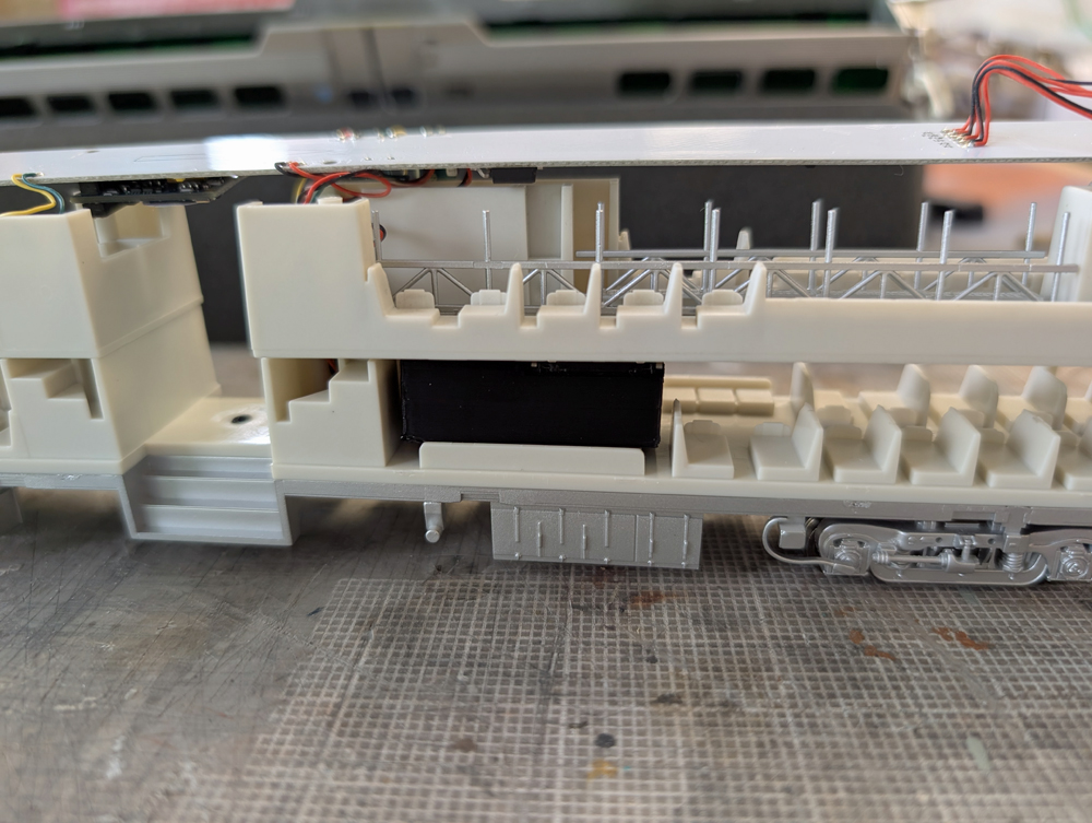 Test fit of a speaker in an HO scale passenger car