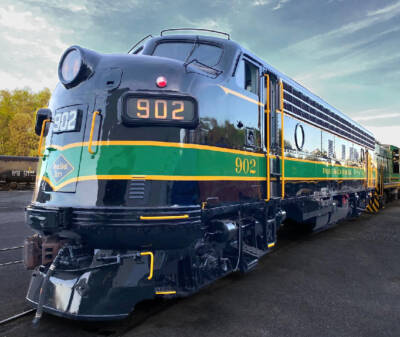 Black bulldog-nosed diesel locomotive with green and yellow stripe.