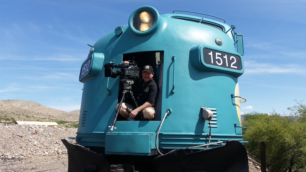 Man with camera standing in front of diesel locomotive
