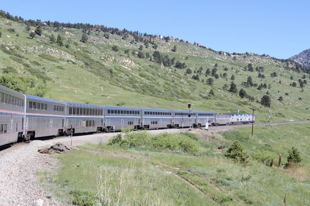 Passenger train with three locomotives in mountainous area