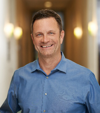 Man in blue shirt in building hallway