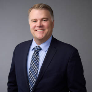 Head and torso photo of smiling man in suit