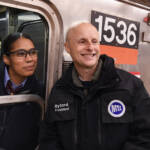 Woman in subway train poses with man on platform