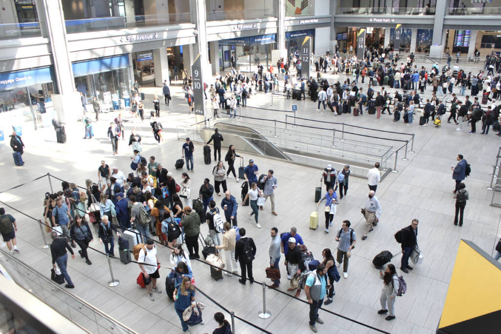 People in station waiting room lined up to board trains