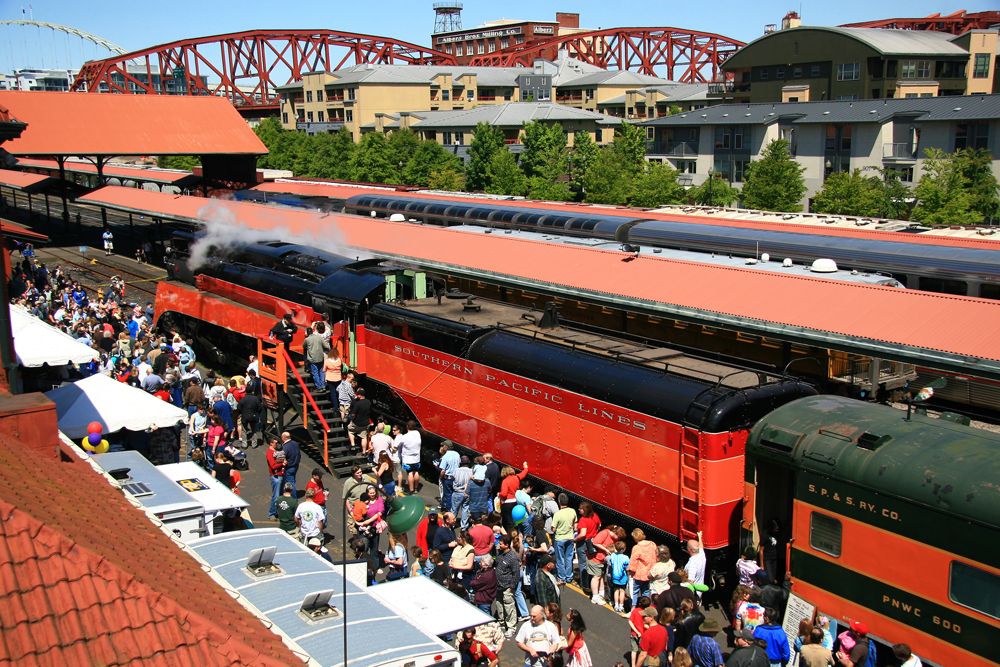 Steam locomotive at passenger station with large crowd