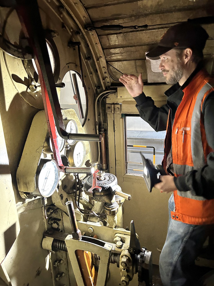 Man in safety vest in cab of rotary snowplow