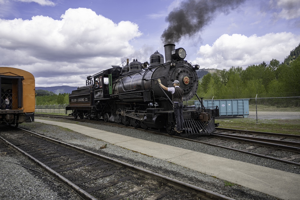 Man riding front of steam locomotive