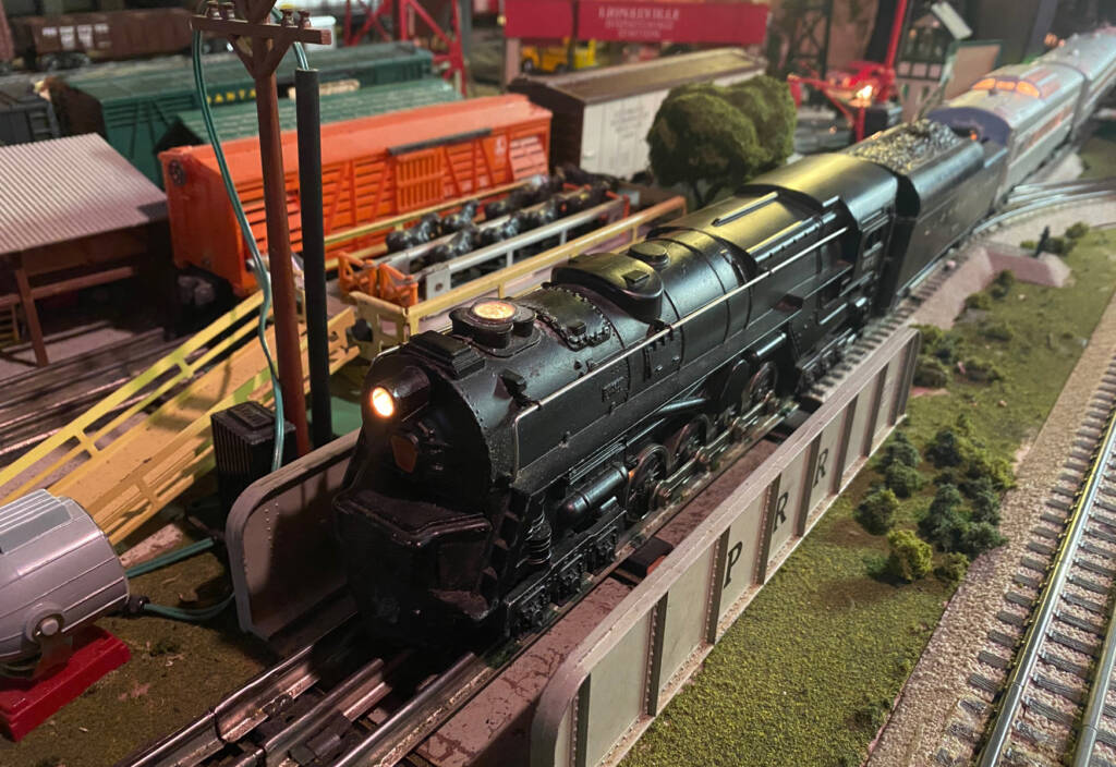A black toy train locomotive on a toy train layout