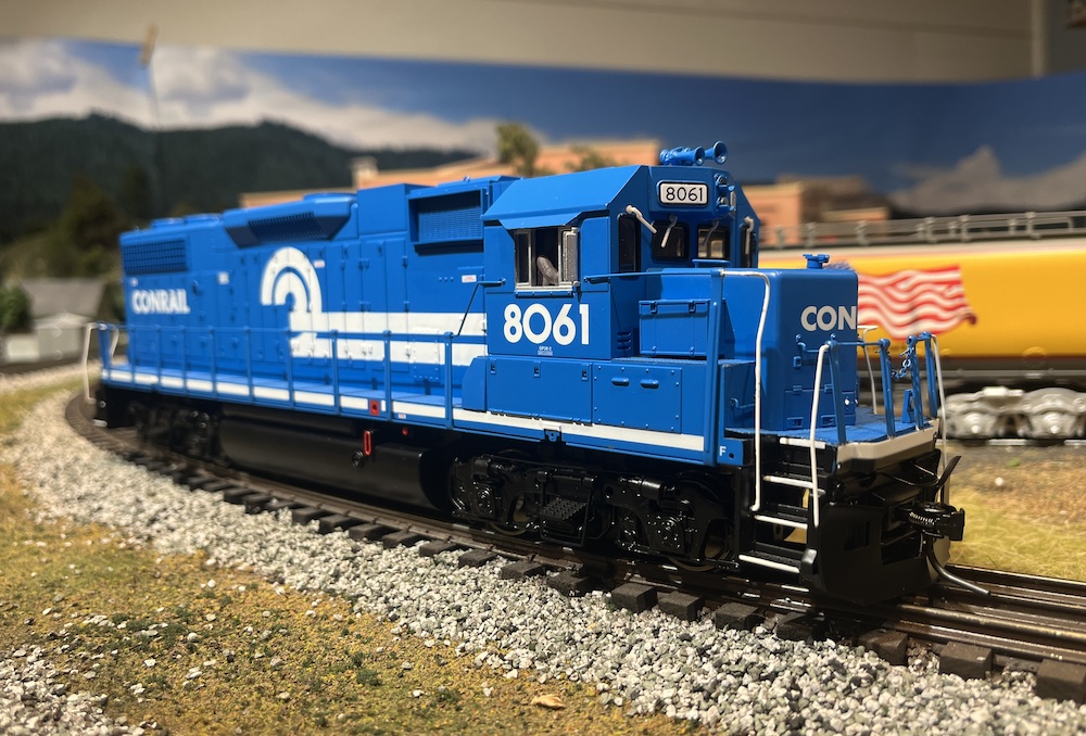 blue and white model locomotive on curve
