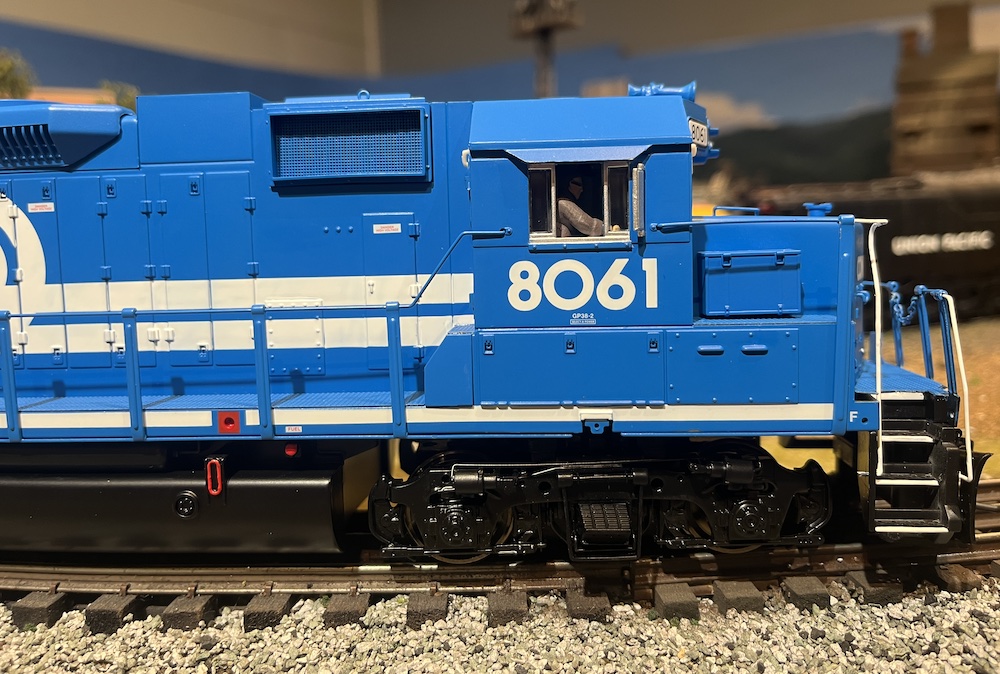 side of blue and white model locomotive on train layout