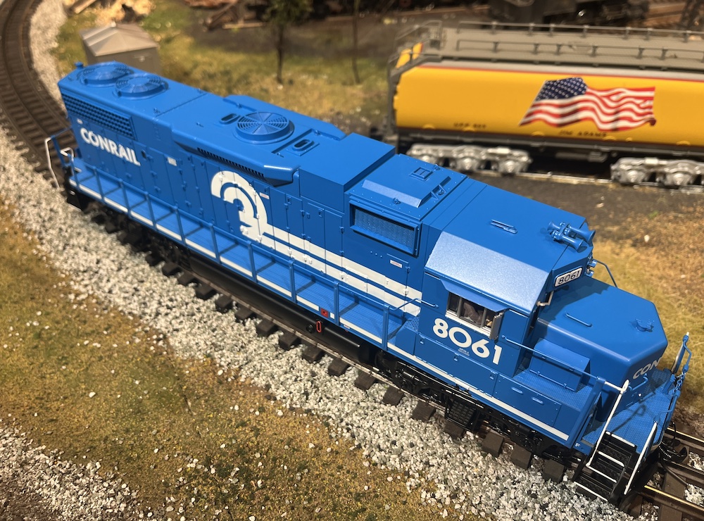 looking down on a blue and white model locomotive on train layout
