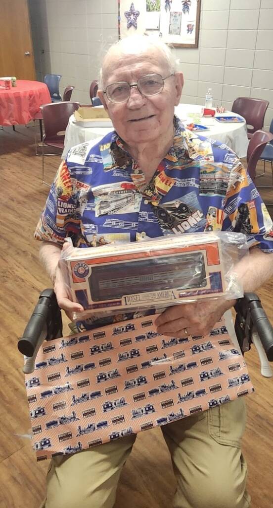older man sitting with boxcar in his lap