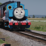 smiling locomotive on track with people watching
