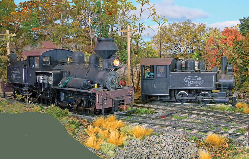 Color photo of two steam locomotives on scenicked model railroad.