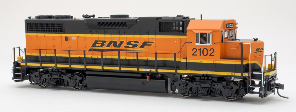 Color photo of O scale locomotive painted orange and black with yellow stripes on white background