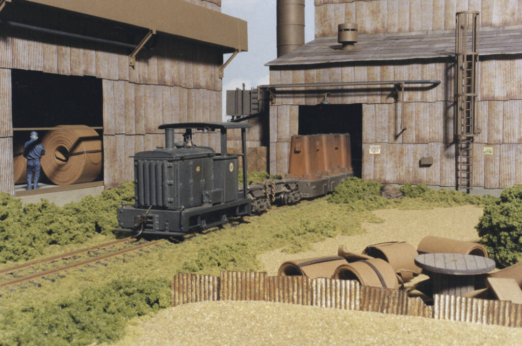 A model switching locomotive with ingot cars on a model railroad layout