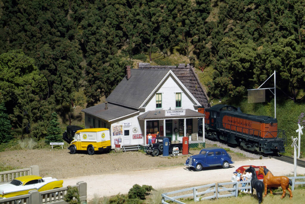 A train past a white general store