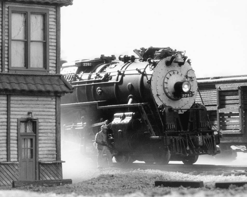 A black and white photograph of a model steam locomotive