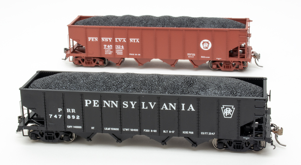 Color photo of HO scale freight cars painted mineral red and black on white background