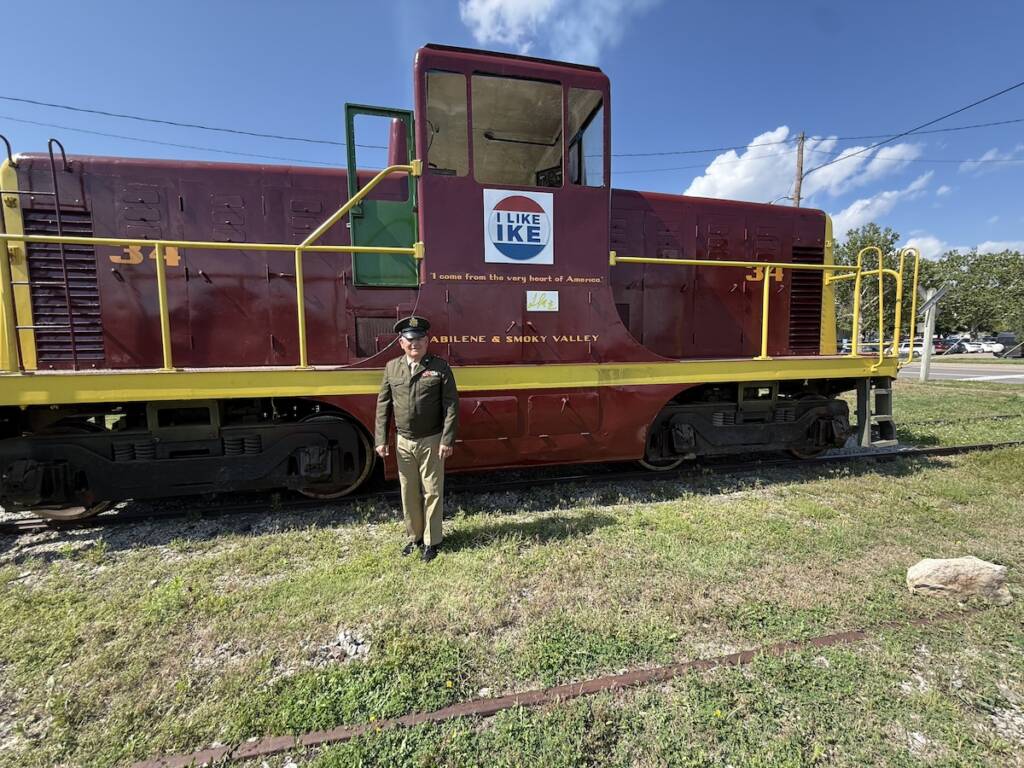 Veteran standing in fromt of restored diesel