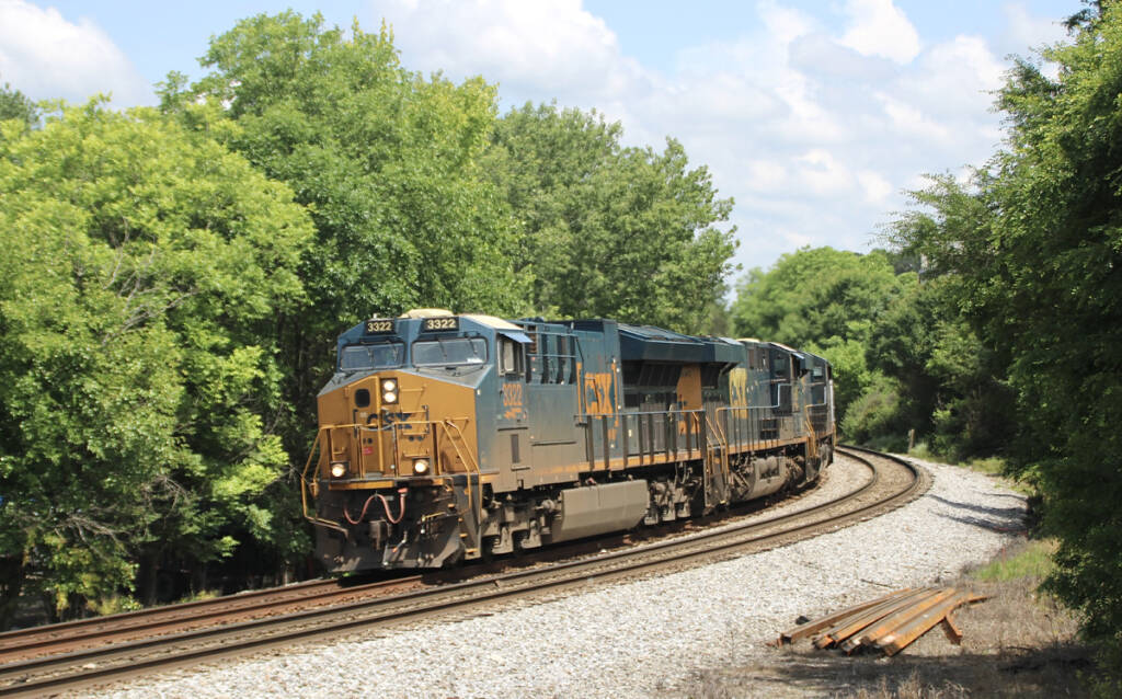 Freight train with blue and yellow locomotives rounding curve