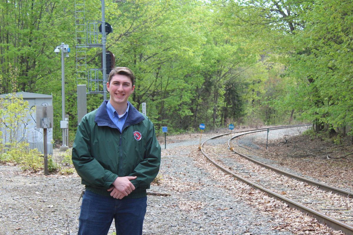 Man standing in front of curve on rail line
