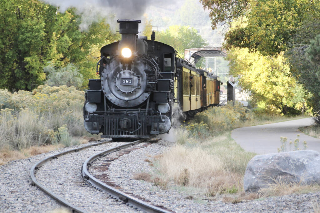 Steam-powered passenger train approaching curve