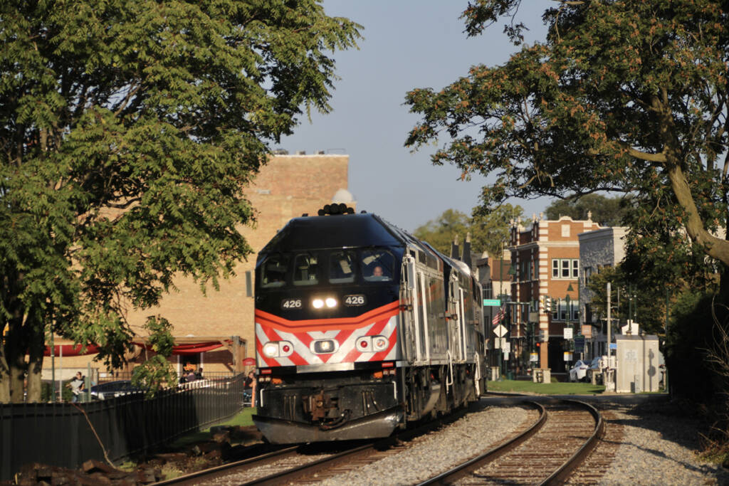 Commuter train rounds curve through downtown of small town
