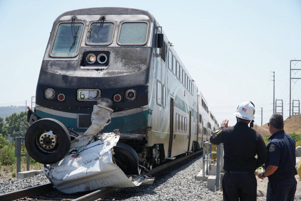 Wreckage of truck pinned against front of commuter train cab car