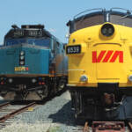 Yellow and blue passenger train next to current VIA Rail Canada equipment
