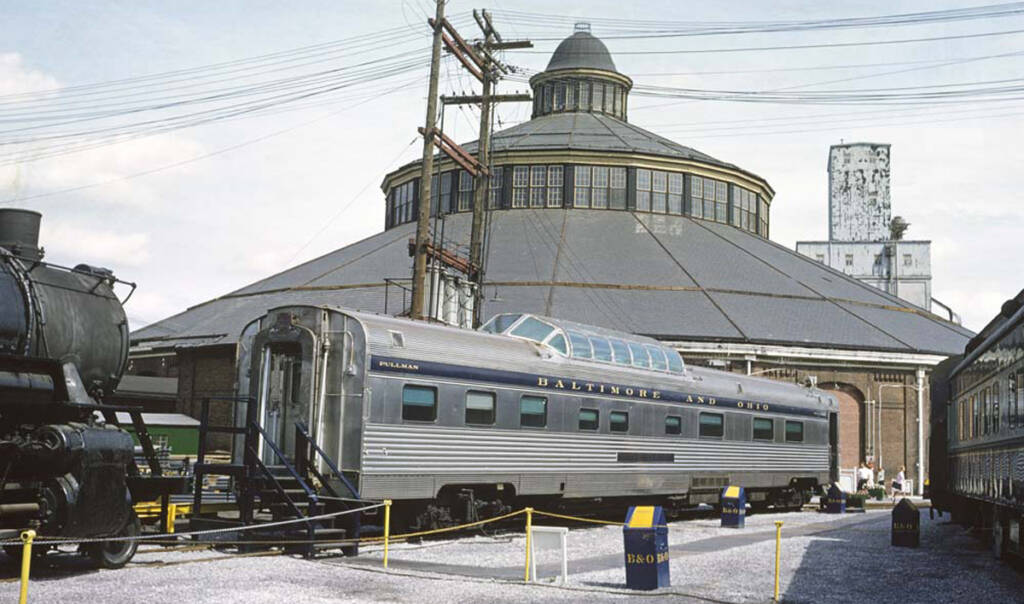 Stainless steel dome car outside brick roundhouse at museum