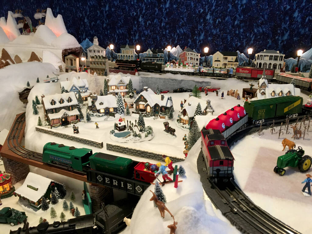 A winter scene on a toy train layout featuring an ice skating rink