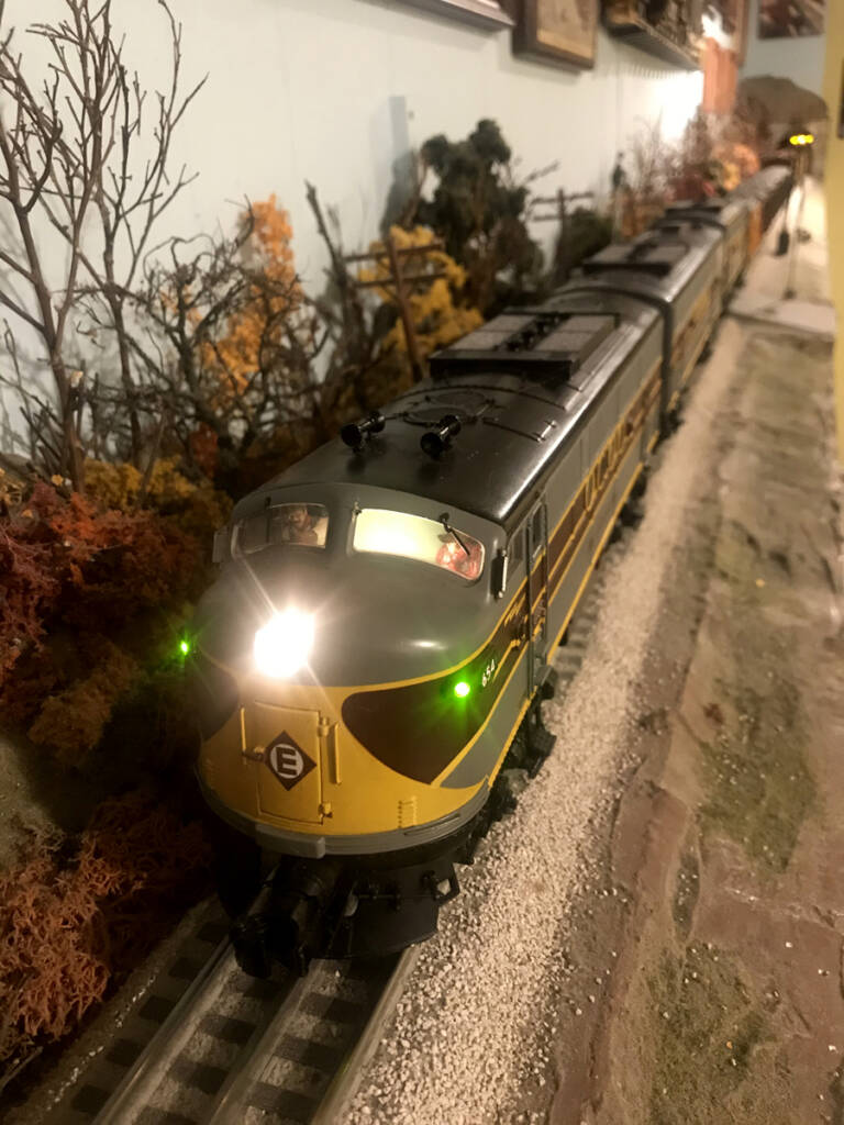 A photo of an illuminated toy train approaching the camera