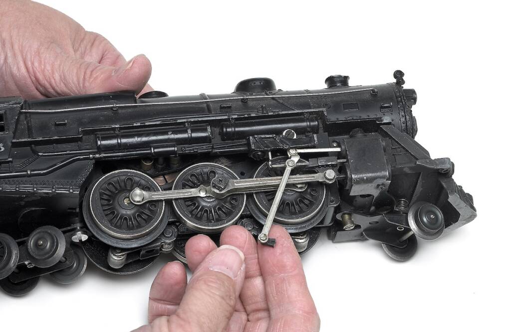 hands holding model locomotive with broken part