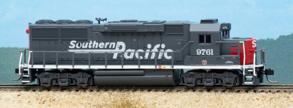 Color photo of N scale diesel locomotive painted scarlet and gray on scenicked base.