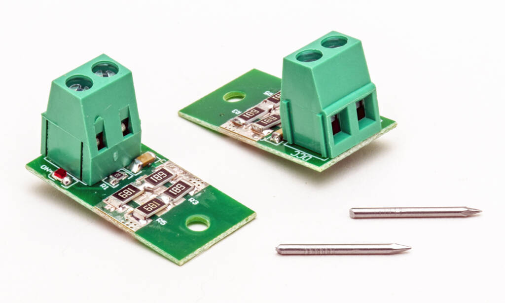 Color photo green printed-circuit boards with screw terminals and two pins on white background