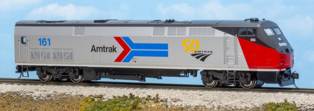 Color photo of modern streamlined HO scale passenger diesel painted red, silver, and black with red, blue, black, and yellow graphics on scenicked base 