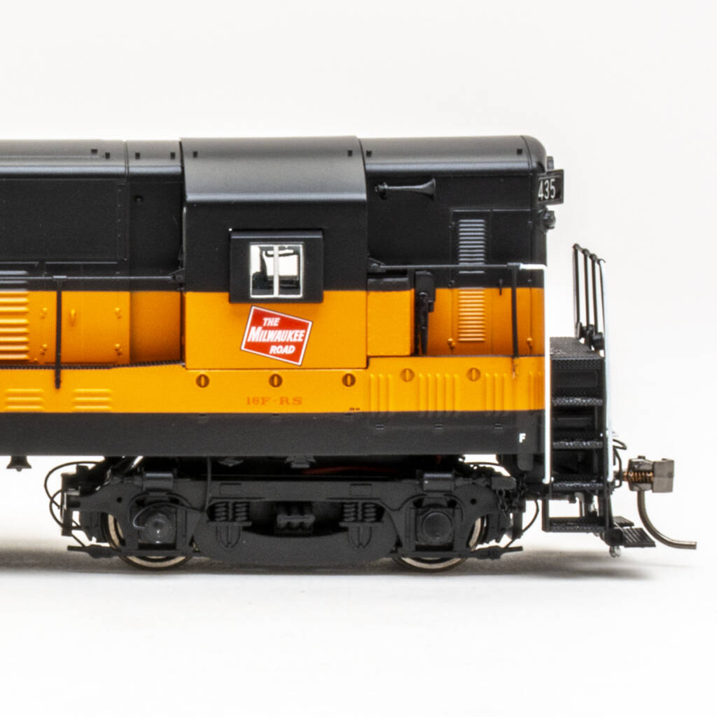 Color photo of HO scale diesel painted orange and black on white background