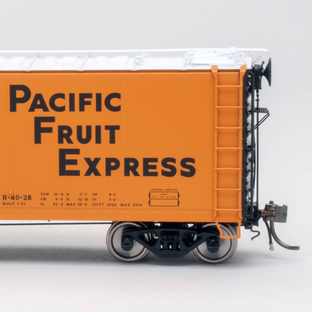 Color photo of HO scale refrigerator car painted orange and black on white background.