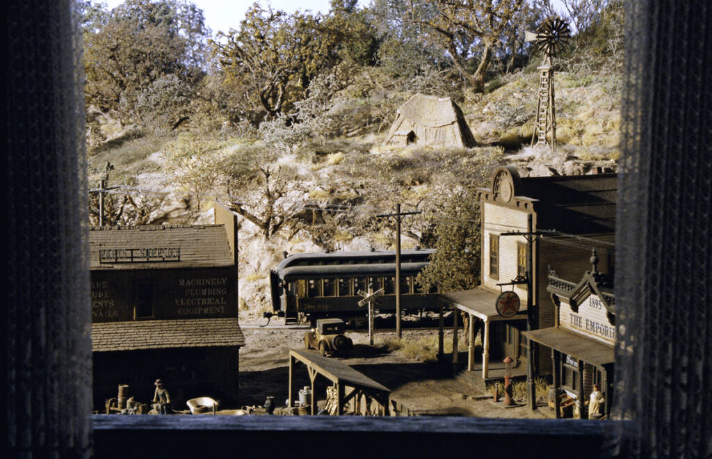 A model railroad layout photographed from inside a hotel window