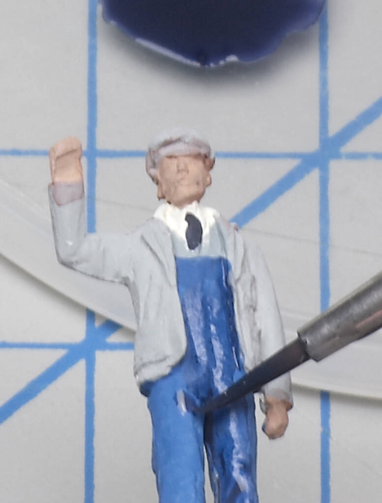 Color photo showing wash being applied to figure with paintbrush.