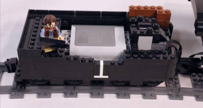 A Lego figure inside of a model Lego locomotive