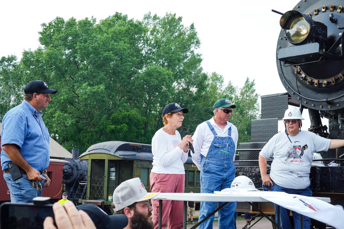 Guest speakers in front of a newly-restored steam locomotive