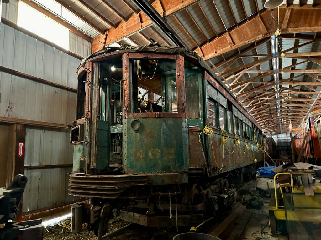 Unrestored trolley car inside a building.